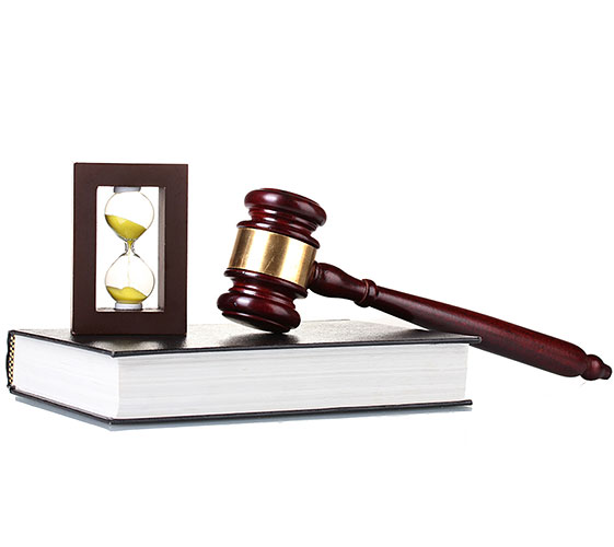 Image of an hourglass and gavel on top of a book