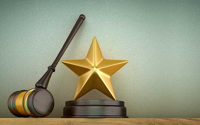 A gavel and stars rest against a greenish-blue wall.